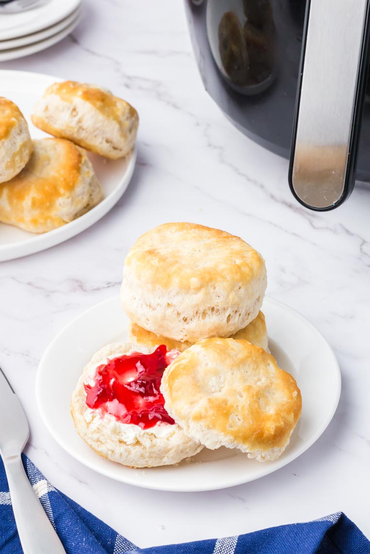a stack of air fryer buttermilk biscuits on a plate with jam on one