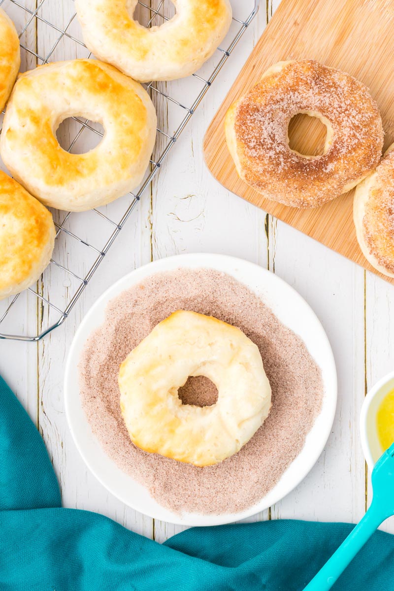 a donut turned upside down in a bowl of cinnamon sugar 