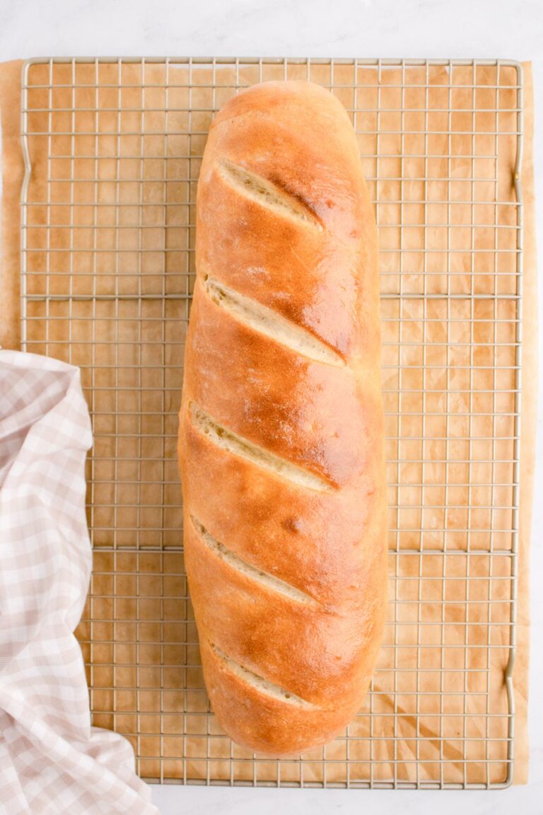 a loaf of baked french bread on a cooling rack