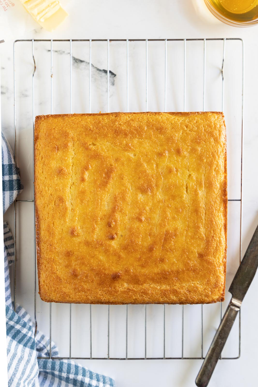 a square of baked Jiffy sweet cornbread on a cooling rack but uncut 