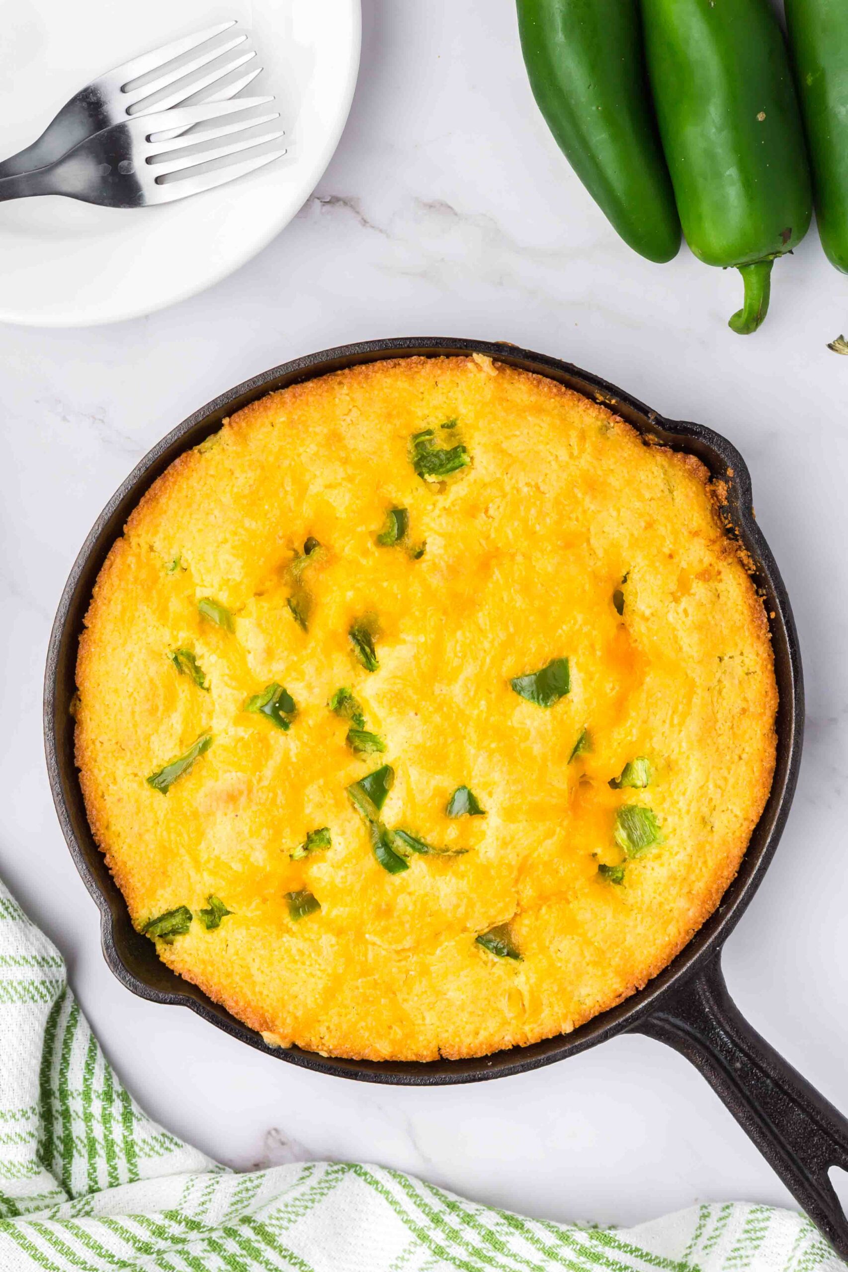 Overhead of a cast iron pan full of perfectly baked Mexican cornbread.