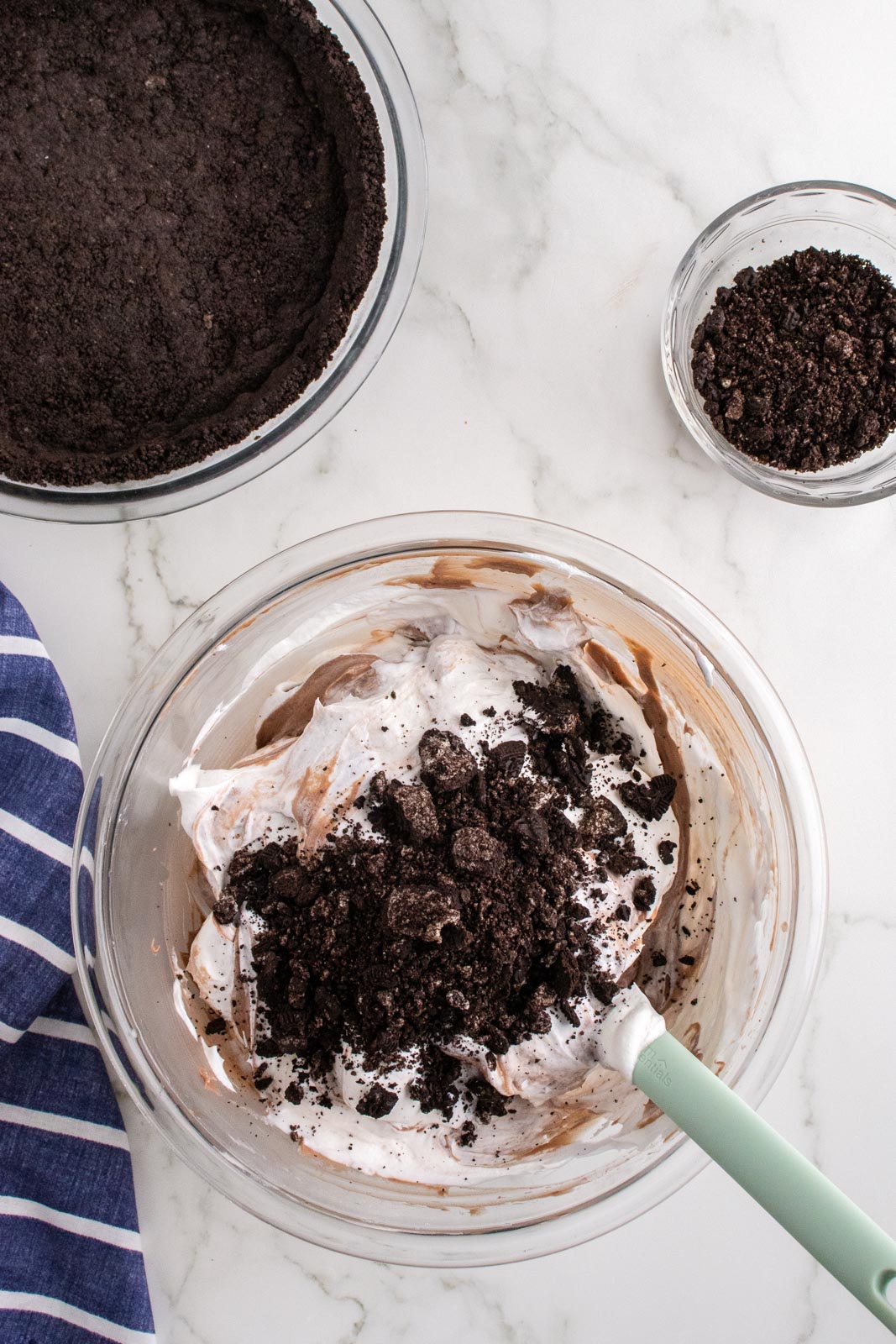 Folding Cool Whip and Oreo crumbs into dirt pie filling.