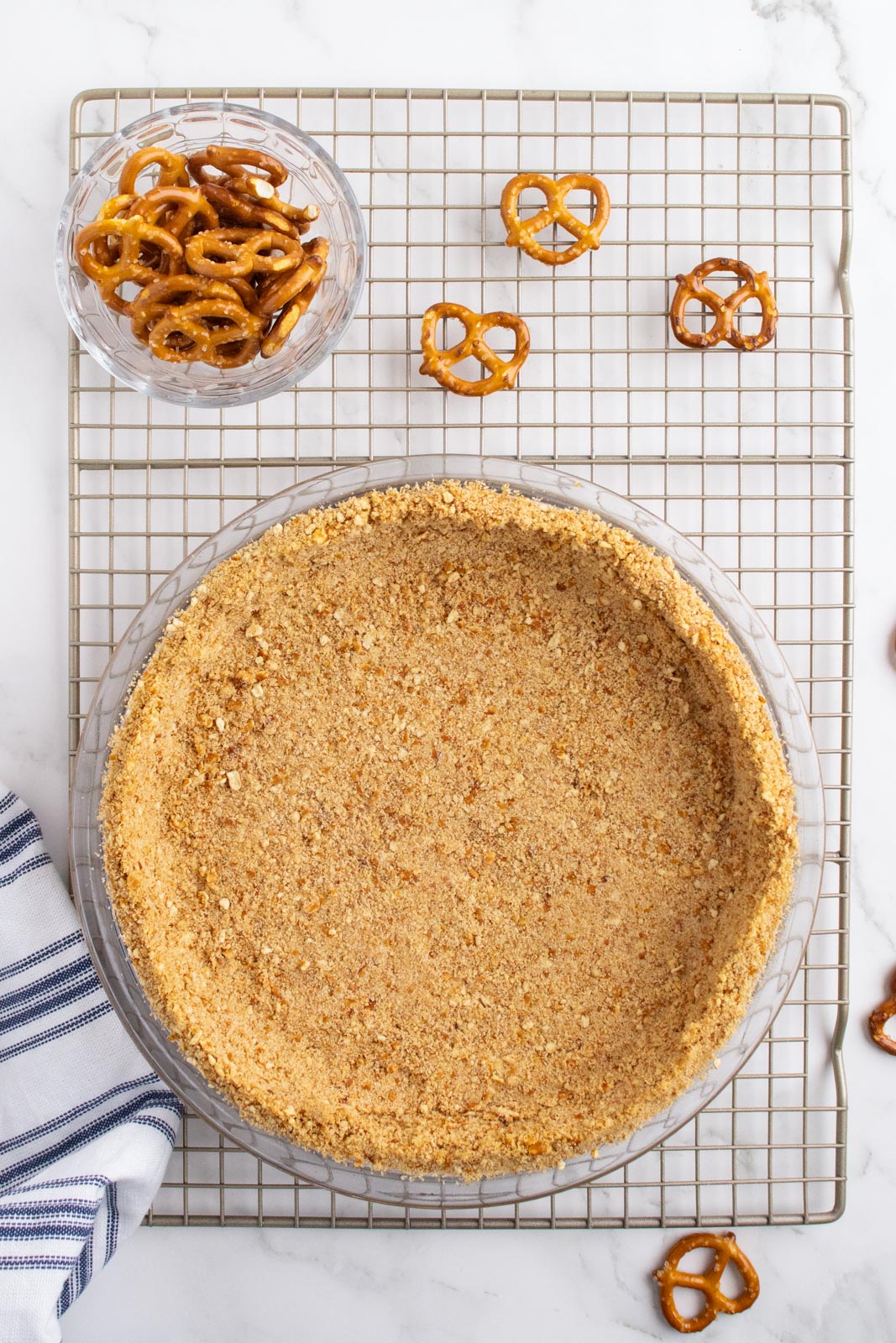 pretzel crumble crust in a pie plate on a cooling rack 