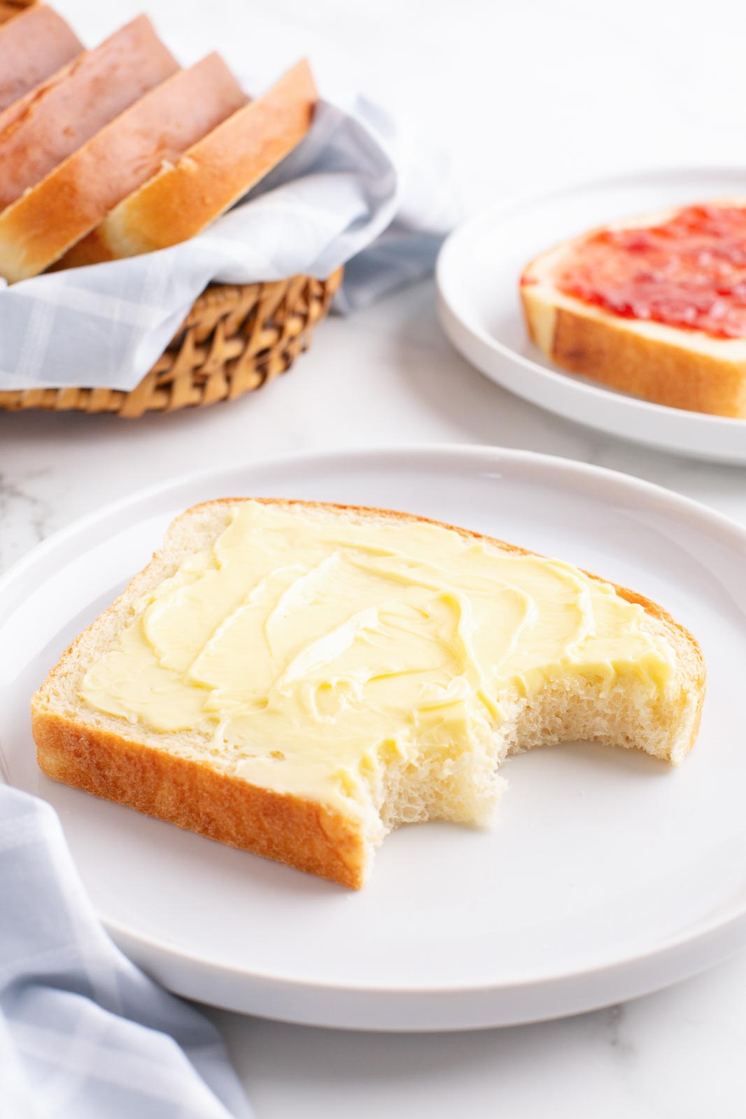 A slice of buttered mashed potato bread on a plate.